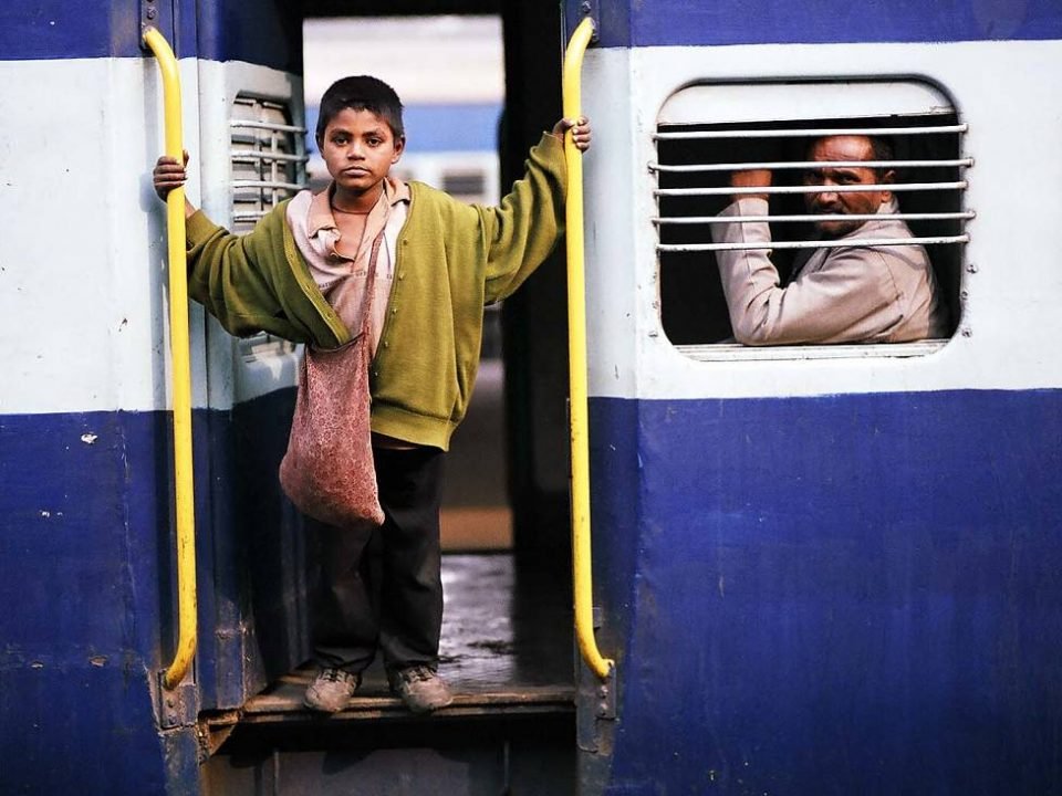 Child standing on the door of train